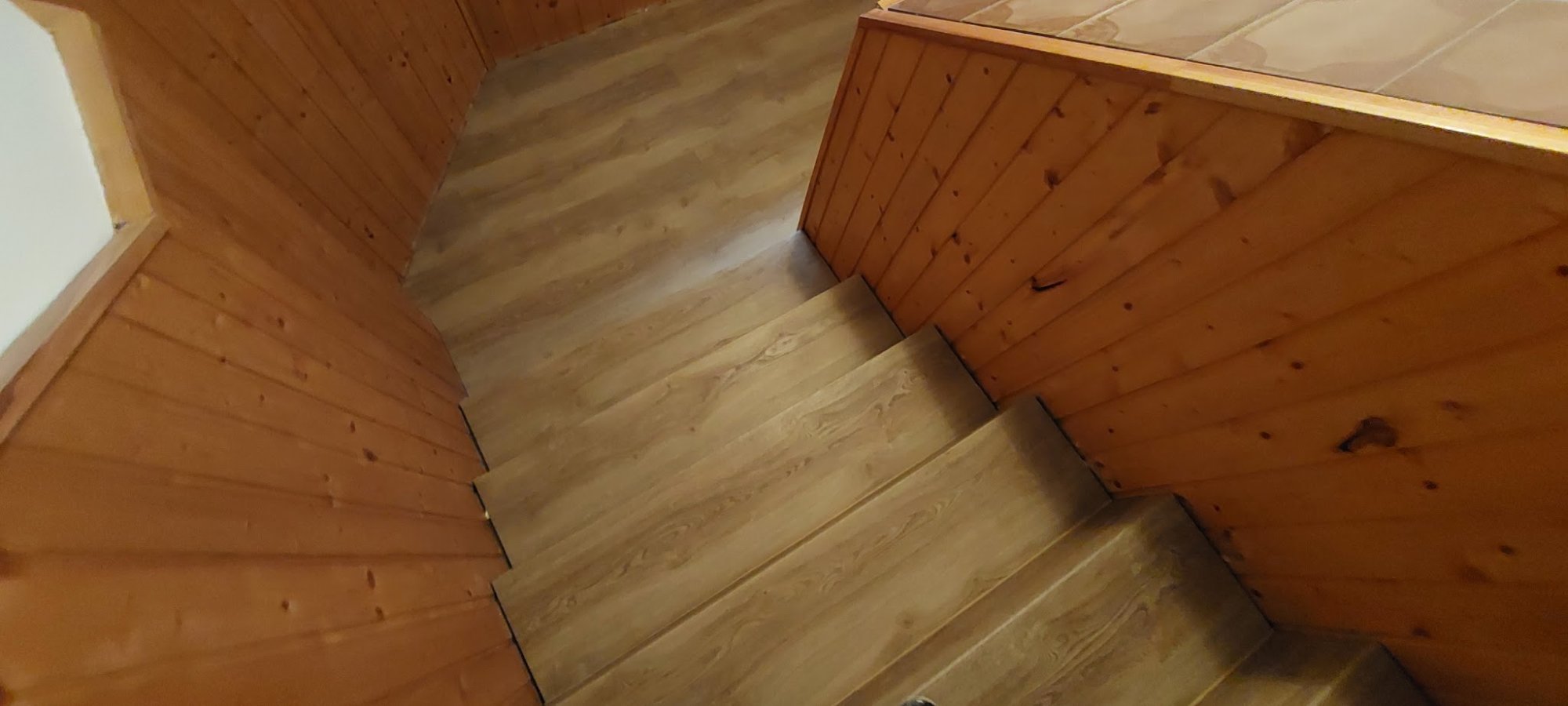 Schodiště v dřevěné chatě s podlahou v dekoru dřeva